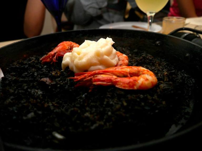 Cava’s Specialty Arroz Negro Squid ink paella with squid and prawns, with garlic aioli 
