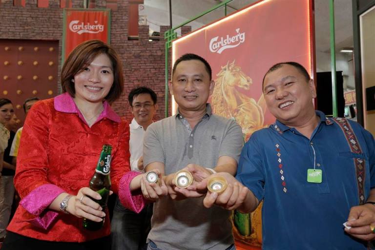 Carlsberg Marketing Director Juliet Yap showing off the bottle caps with the ang pau prizes. Make sure you don't simply throw the bottle caps away without checking first!