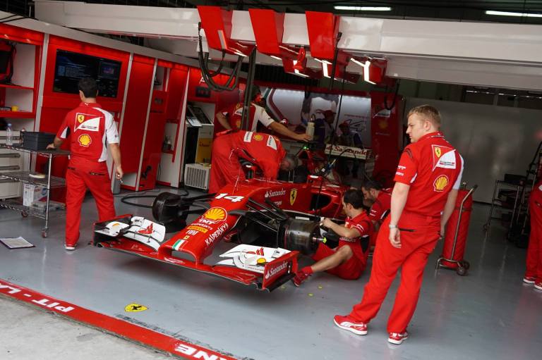 The mechanics and pit crew getting the car ready for the race