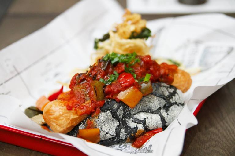 Sloppy Dick - Jumbo chicken sausage on own-made charcoal bun, ratatouille sauce, pickled veggie and onion string fries