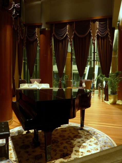A baby grand piano in the lounge section