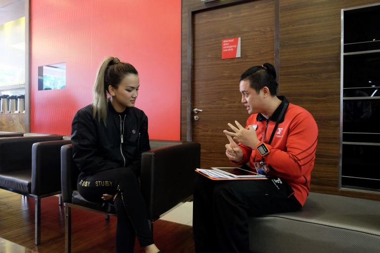 The trainer assisting Stephanie  to fill up the questionnaire